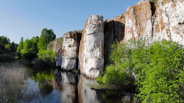 High Snow-white Limestone Cliffs on the Banks of the River. Aerial Photography, a Drone Flies Along