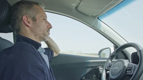 Male driver sitting in an autonomous car, letting the car drive by itself