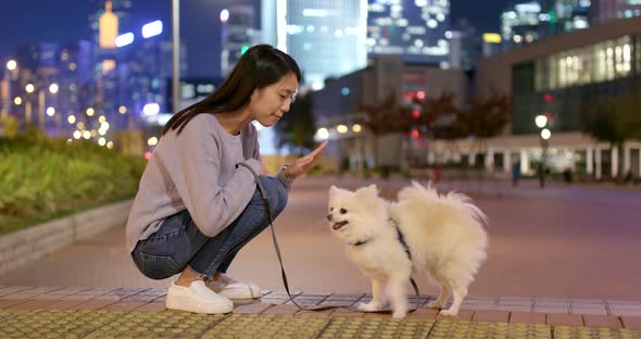 Woman train her dog in city at night