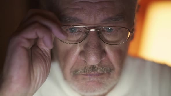 Portrait of an Elderly Grayhaired Man with Glasses Looking at a Laptop Screen a Focused Man Reading