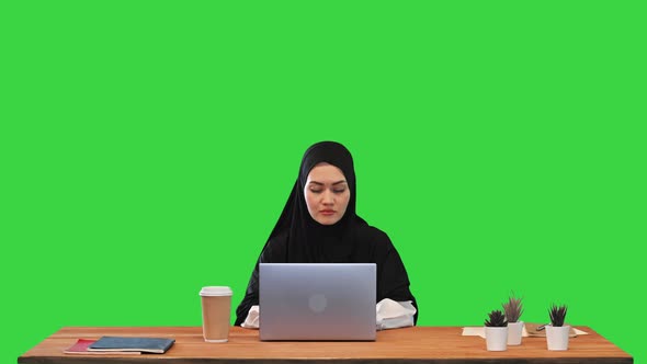 Pretty Young Middle Eastern Woman Wearing Hijab Using Laptop on a Green Screen Chroma Key