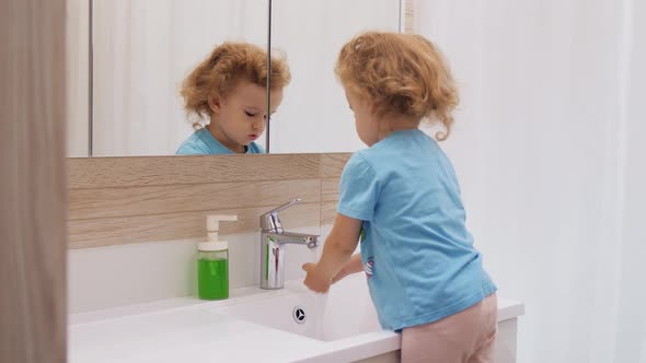 Young Girl Washing Hands with Water
