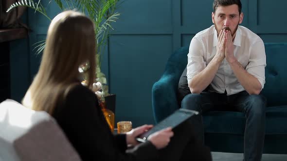 Man Client Sitting with Female Psychologist on the Comfortable Couch During the Psychological