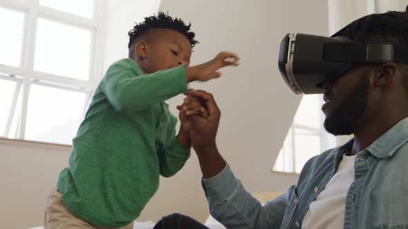 Father and son at home using VR