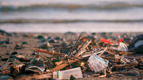 Plastic Bottles, Bags and Other Garbage Dumped on Dark Sand of Ocean Beach.