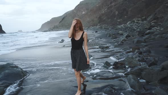 Young Woman in a Beautiful Dress Walks Along the Black Volcanic Black Sand Beach Benijo in the North