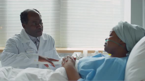 Doctor Visiting Sick Black Woman in Hospital Ward