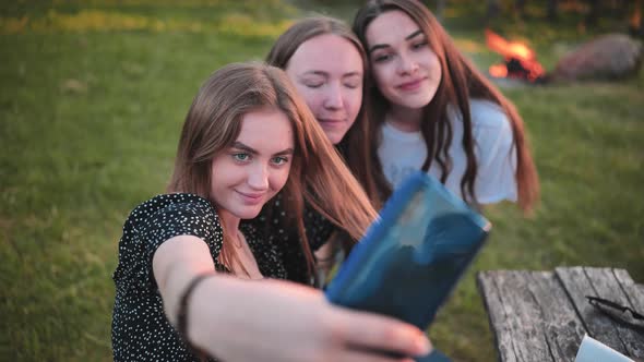 Three Girls Schoolgirls Make Selfies Using a Smartphone