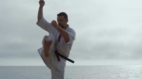 Man Making Karate Kicks on Seacoast Close Up