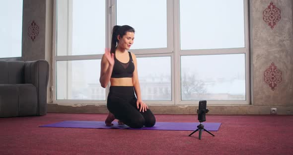 Pretty Slim Girl Trainer Blogger Doing Yoga Showing Video Class Via Smartphone