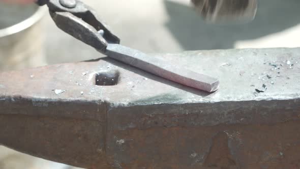 Blacksmith Forges Metal With A Hammer On The Anvil