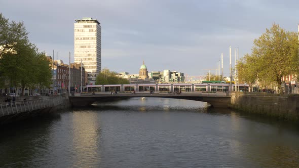 SIPTU Headquarter At Liberty Hall With Tram Crossing Rosie Hackett Bridge In Dublin, Ireland. - wide