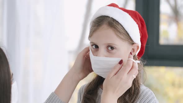 Mother Putting on a Mask on Daughter's Face