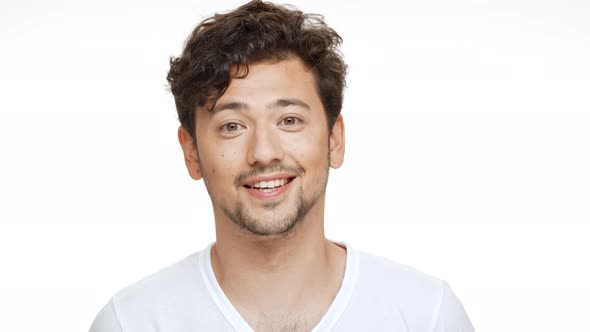 Young Handsome Man Smiling Looking at Camera Over White Background