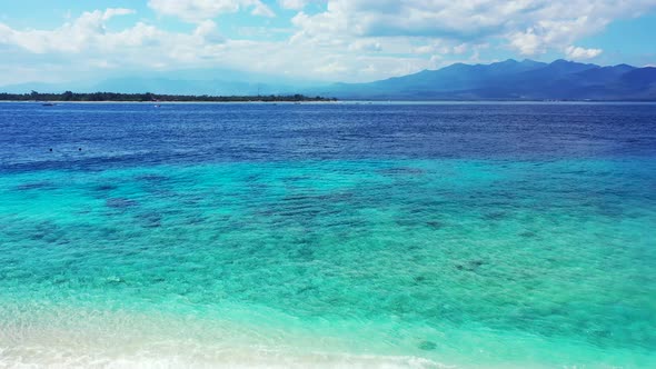 Wide angle aerial abstract shot of a white sandy paradise beach and blue sea background in vibrant 