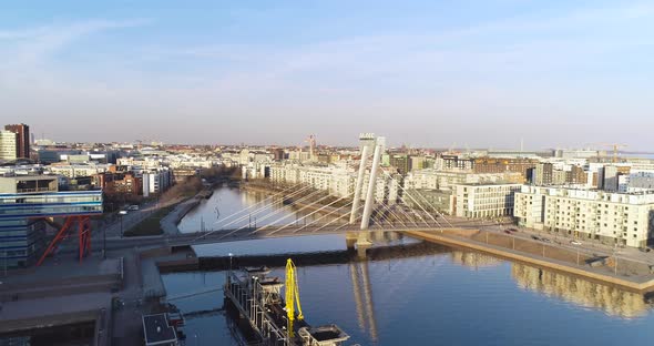 Forward moving aerial shot that moves past a bridge in Ruoholahti, Helsinki.