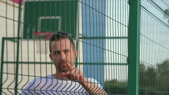 Basketball Player Holding a Ball Pointing at you Posing at Outdoor Court