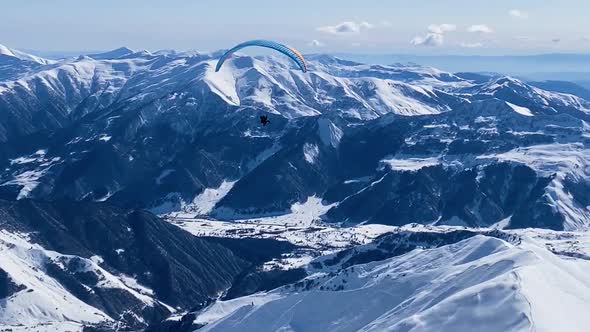 Paroplane Fly Above Winter Mountains Landscape.