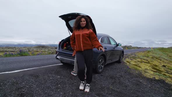 Drone of Smiling Woman by Car at Roadside