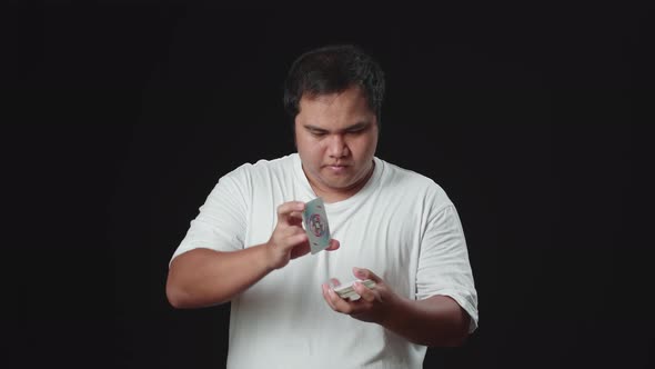 Asian Magician Is Making Trick With Cards, Cardistry On Black Background