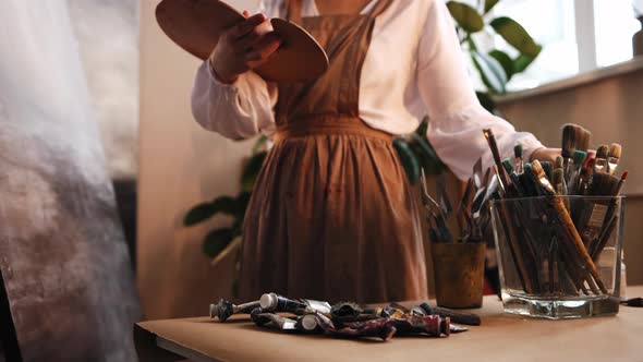 Art Studio  Young Woman Artist Working with a Painting