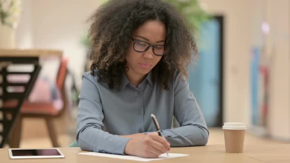 Hardworking Young African Woman and Writing on Paper