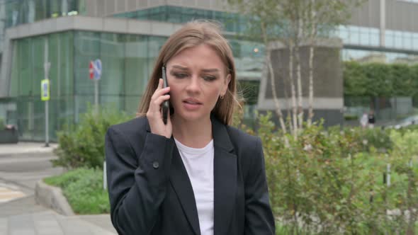 Angry Businesswoman Talking on Phone While Walking on the Street