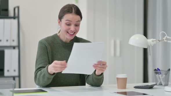 Young Woman with Documents Celebrating Success
