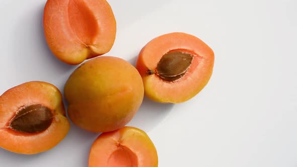 ripe apricots rotating on a white background