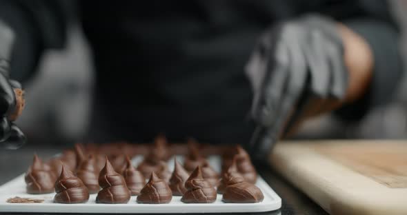 Chef Chocolatier in Black Gloves Rolls Up Small Candies From Self Cooked Chocolate in Slow Motion