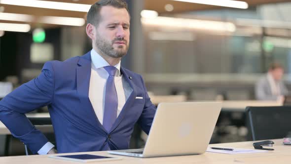 Middle Aged Businessman Having Back Pain At Work