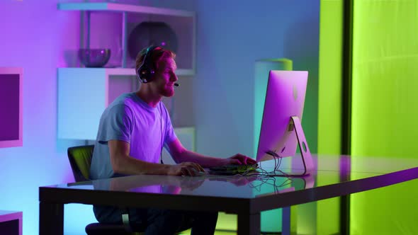 Excited Man Celebrating Gaming Tournament Victory in Neon Cyberspace at Home