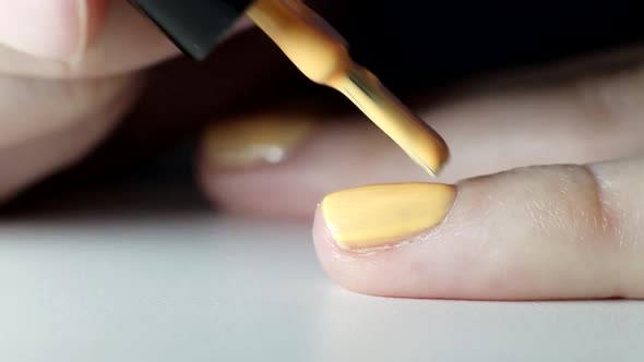 Girl Does a Manicure on Nails, Applies Orange Nail Polish, Beauty Salon, Macro