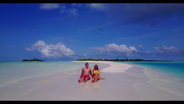 Young couple engaged on exotic island beach holiday by clear ocean and bright sand background of the