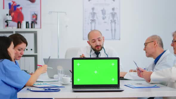 Team of Physicians Using Laptop with Green Screen in Front of Camera
