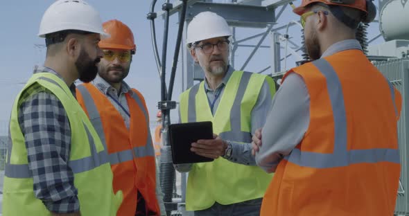 Foreman Speaking with Colleagues on Power Station