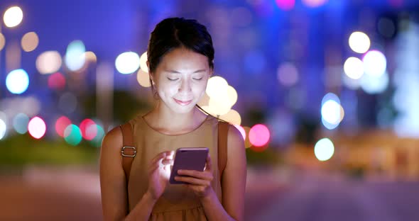 Young Woman use of smart phone in city at night
