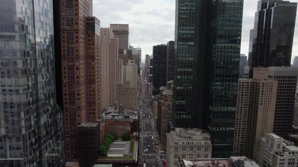 Flying between buildings towards the Times square in cloudy, New York, USA - Aerial view