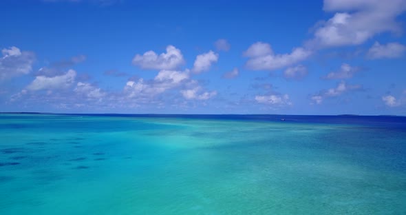 Luxury flying tourism shot of a sunshine white sandy paradise beach and turquoise sea background 