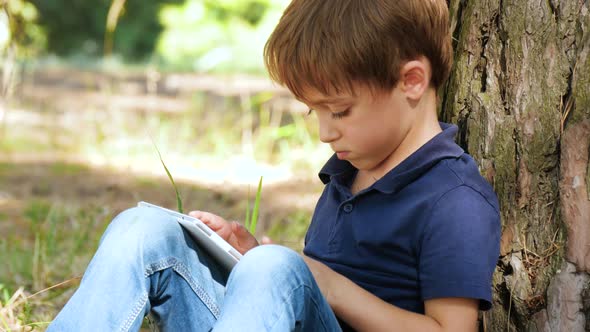 Portrait of a Little Boy with a Tablet. Happy Child Playing in the Tablet Against the Background