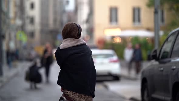 Autumn Depression and Melancholia, Woman Is Walking on City Street and Listening To Music By