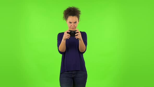 Curly Woman Playing a Video Game Using a Wireless Controller and Loses. Green Screen