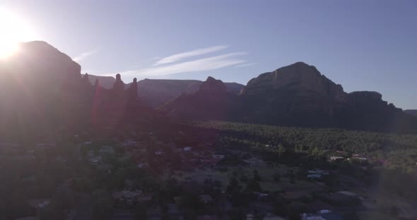 Droneing in over Sedona with sun behind the mountains , AZ