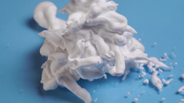 Shaving Cream Pouring From The Top Onto The Glass Table