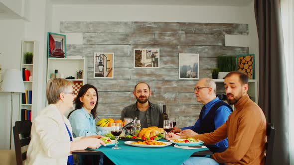 POV Shot of Family at Dinner Having a Video Call with Friends