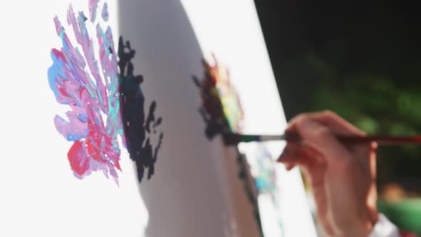 Midsection of caucasian woman painting in sunny garden