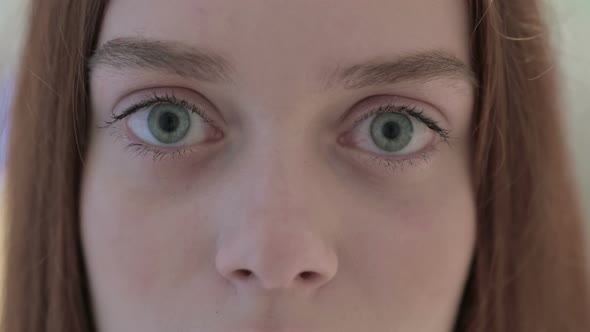Close Up of Blinking Eyes of Young Woman at Camera