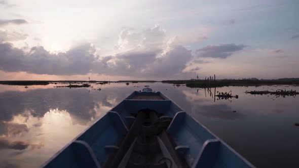 Boat Sailing on the Marshland at Sunset