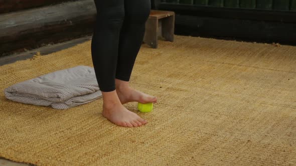 Woman doing foot massage with tennis ball