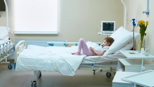 Little girl laying alone in hospital room